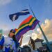 Caprichoso faz o hasteamento do pavilhão azul e branco ao lado da bandeira LGBTQIAPN+